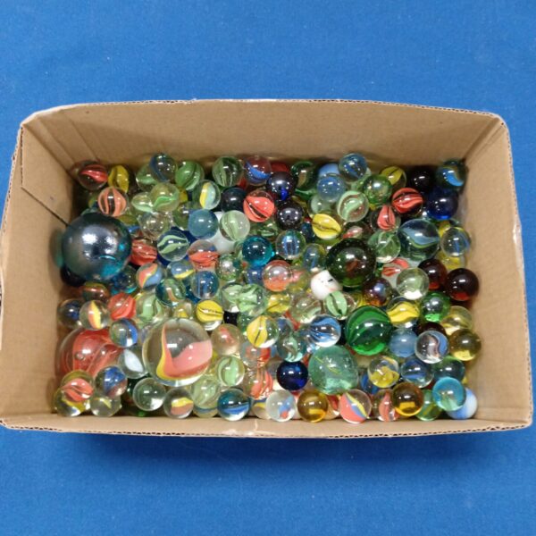 Colourful mixed marbles in a cardboard box, vintage toy collection.