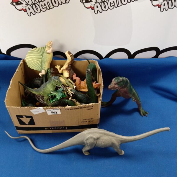 A box of vintage plastic toy dinosaurs for collectors.