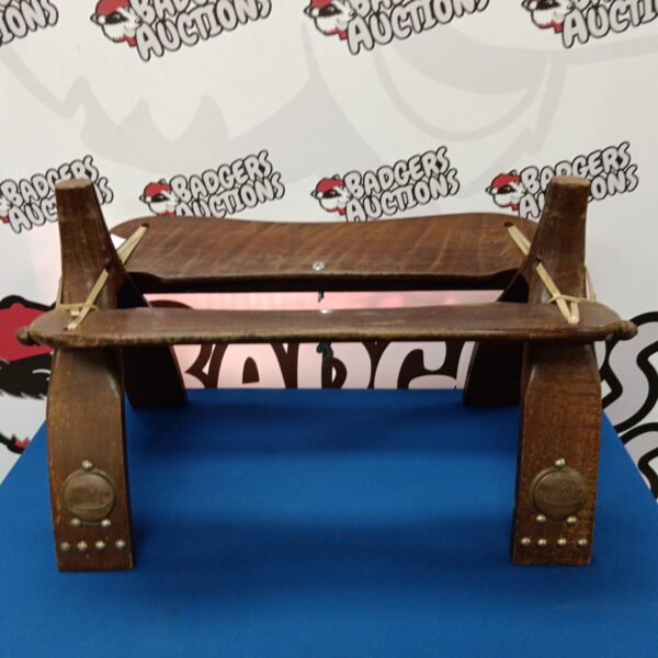 Vintage camel saddle with woven seat and wooden frame.