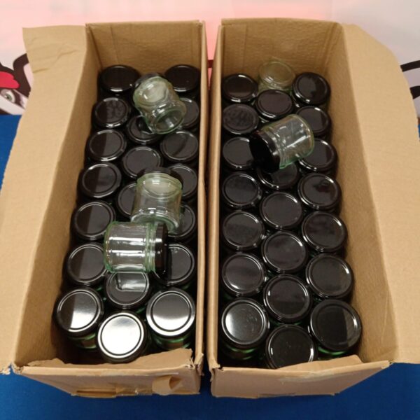 Lot of approximately 90 small glass preserve jars for canning.