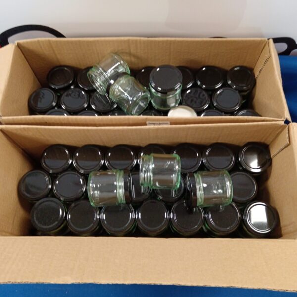 Lot of approximately 90 small glass preserve jars for canning.
