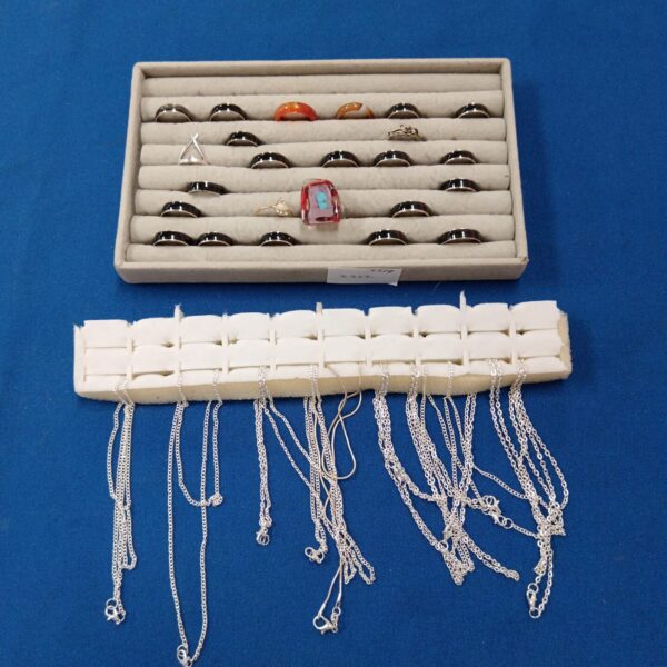 Collection of silver tone rings and necklaces in a jewellery lot.
