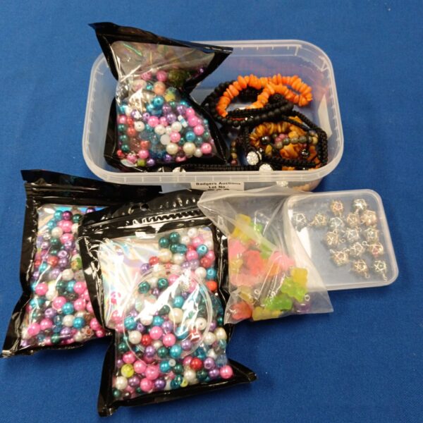 Colourful jewellery making beads in a clear storage tray.