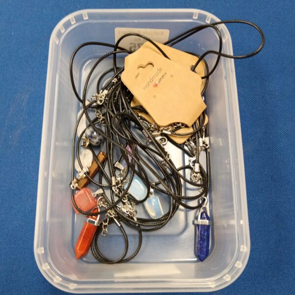 Tray of semi precious stone necklaces with colourful pendants.