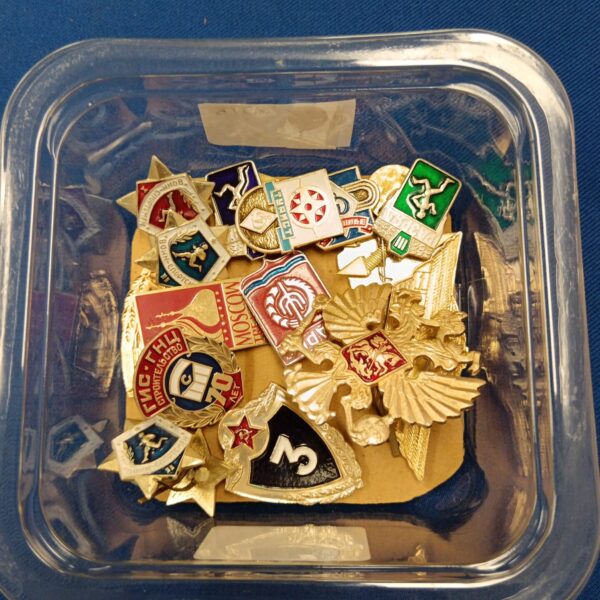 Tray of assorted Russian and Soviet pin badges for collectors.