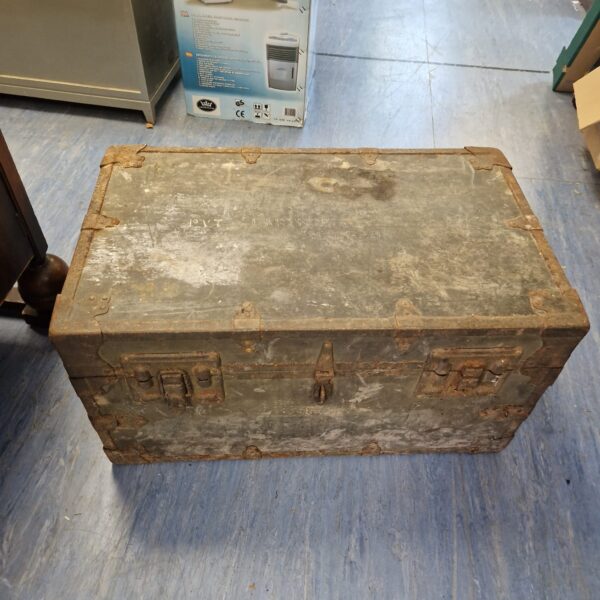 Front view of a weathered vintage military trunk.