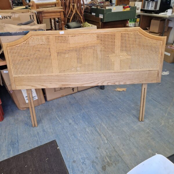 Vintage rattan headboard for a double bed with woven detail.