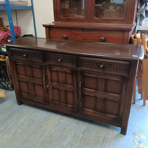 Vintage dark wood sideboard with cupboard and drawers.