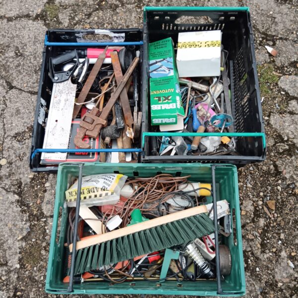 Tray of mixed tools and hardware, including a mallet and broom head.