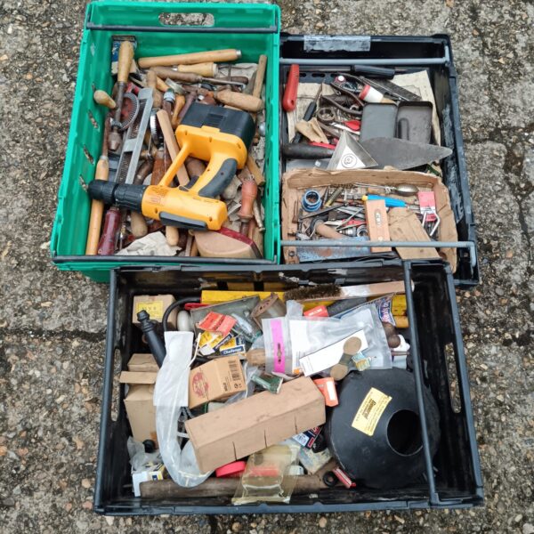 Assorted hand tools and hardware in a green tray.