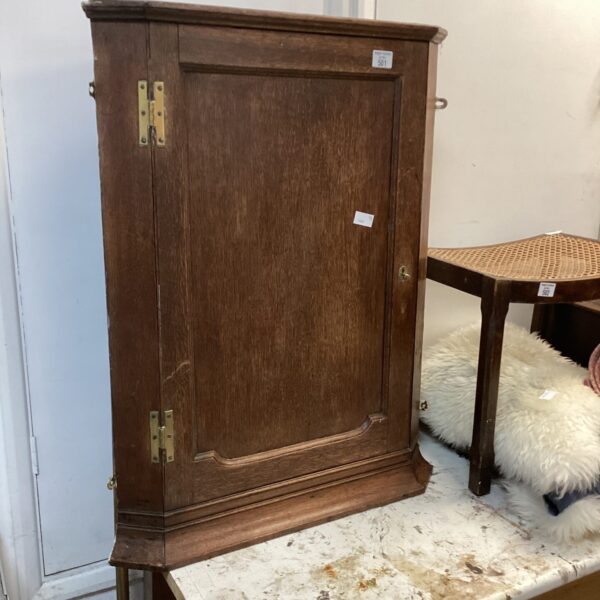 Vintage wooden corner hanging cabinet with a single door.