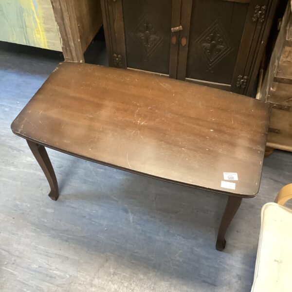 Dark wood coffee table with curved legs, vintage style.