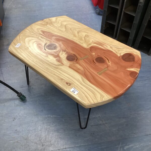 Unique redwood coffee table with minimalist wire legs.