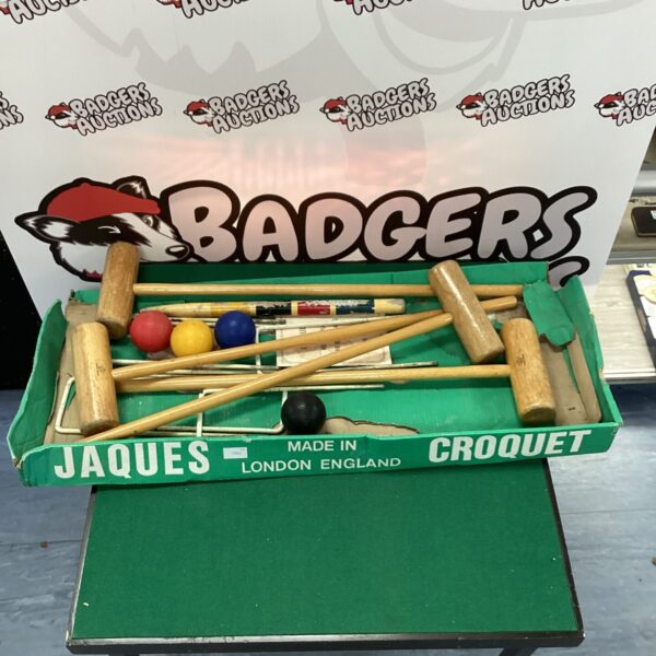 Vintage Jaques croquet set with wooden mallets and balls in a garden setting.