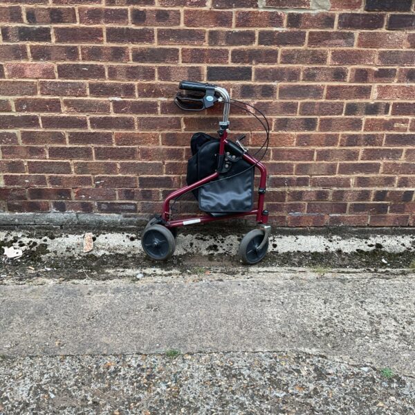 Side view of a foldable mobility trolley with a fabric basket.