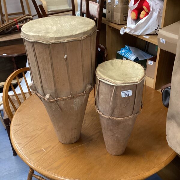 Pair of handmade wooden bongos on a table.