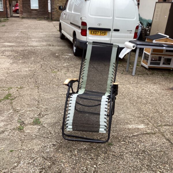 Folding garden sun lounger in a residential setting.
