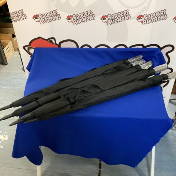 Lot of five new black folding umbrellas for rain protection.