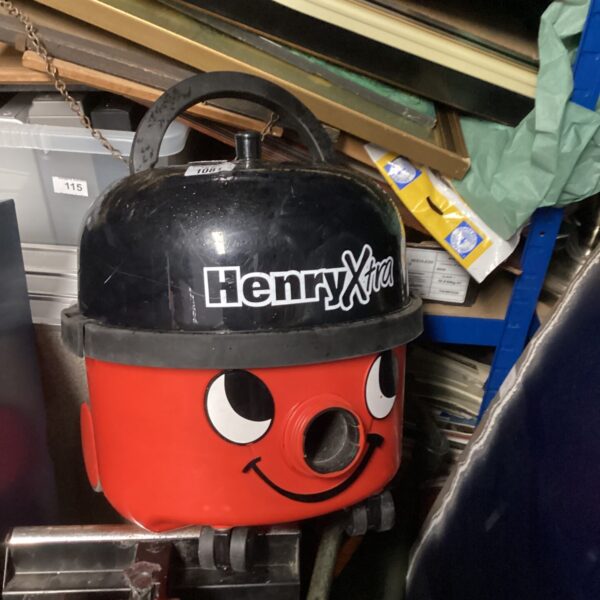 Red Numatic Henry vacuum cleaner with a smiling face.