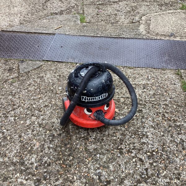 Red Numatic Henry vacuum cleaner, vintage industrial cleaning equipment.