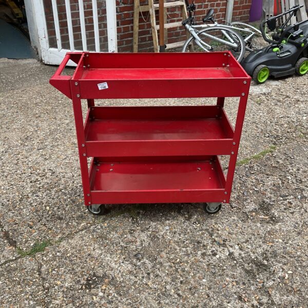 Red metal work trolley with three tiers for workshop storage.