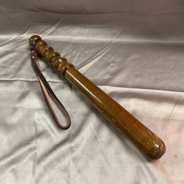 Vintage wooden police truncheon with leather strap.