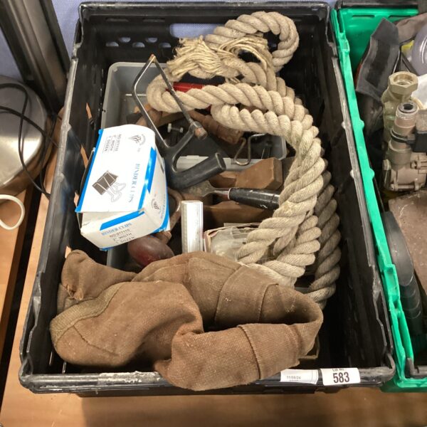 Black crate filled with mixed tools and rope.