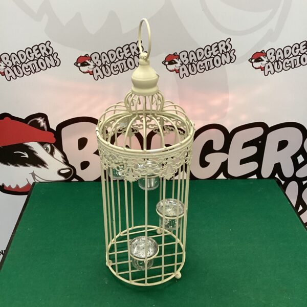 White metal birdcage holding a tea light candle.