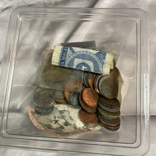 Mixed coin lot in a clear container, vintage currency collection.