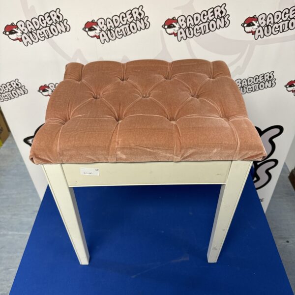 Salmon piano stool with cushioned seat and wooden legs.