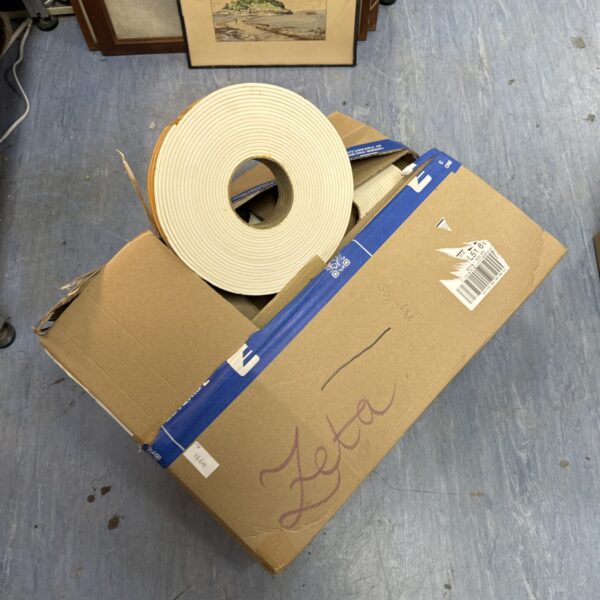 White EPDM foam tape rolls in cardboard box.