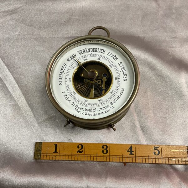 Vintage German desk barometer showing atmospheric pressure.