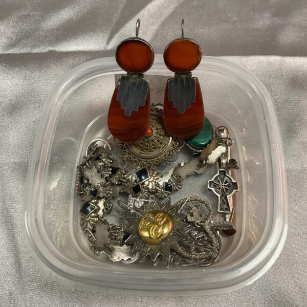 Vintage Art Deco earrings and mixed jewellery lot on display.