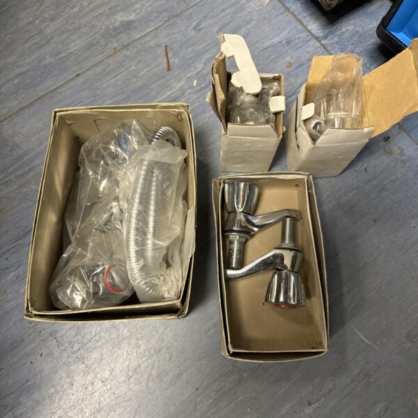 Bundle of chrome bathroom taps and shower heads.