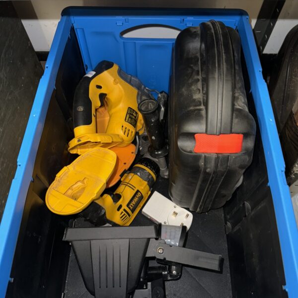 Dewalt power tool lot in blue container, cordless drill visible.