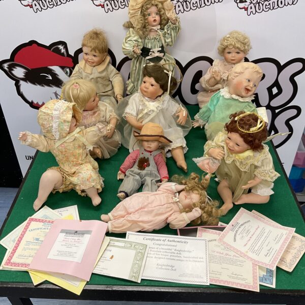 Vintage porcelain dolls with certificates of authenticity displayed together.
