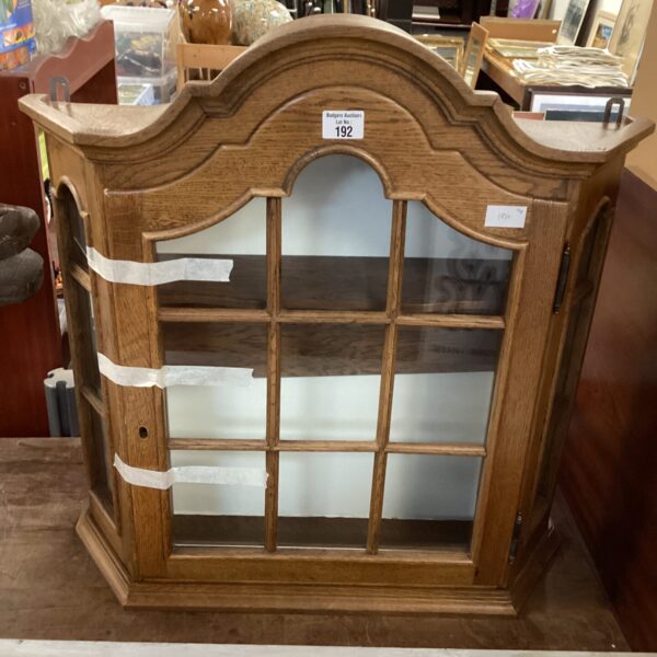 Vintage wooden glass display cabinet for collectibles.