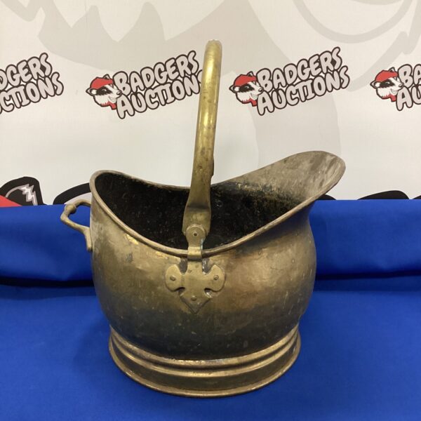 Vintage brass helmet coal scuttle for fireside use.