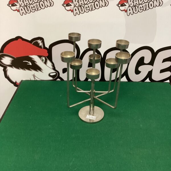 Modern metal candle holder with tiered design for displaying candles.