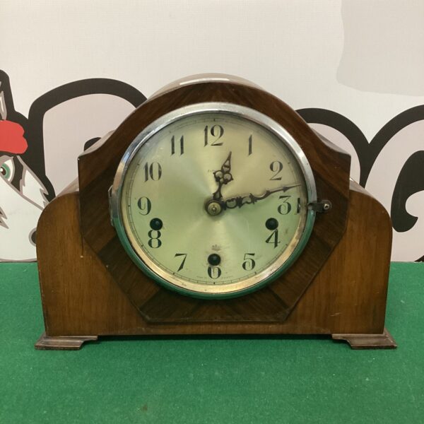 Vintage Enfield mantle clock with wooden case and circular dial.