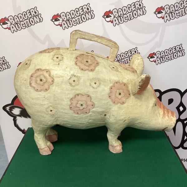 Front view of a vintage papier mache pig money box with floral design.