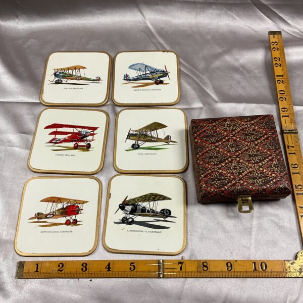 Set of six vintage WWI biplane coasters displayed on a surface.