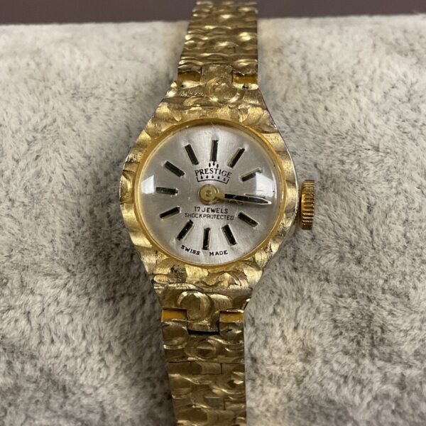 Vintage Prestige ladies watch with gold bracelet and silver dial.