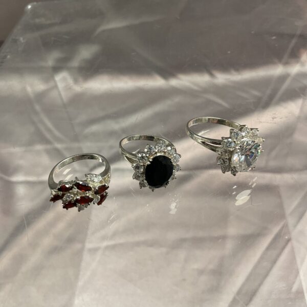 Lot of three silver stone set rings in varying colours.