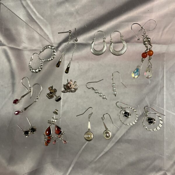 Diverse lot of twelve pairs of silver earrings for sale.