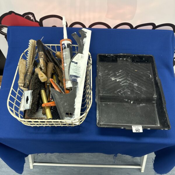 A collection of paint brushes and decorating tools in a plastic crate.