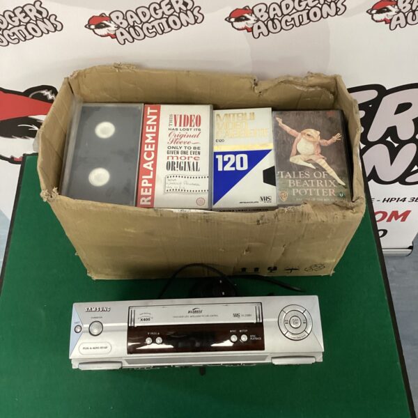 Vintage Samsung VCR with box of VHS tapes, retro video player.
