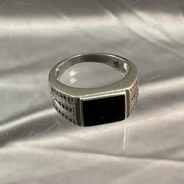 Close-up of a silver ring with a black onyx stone.