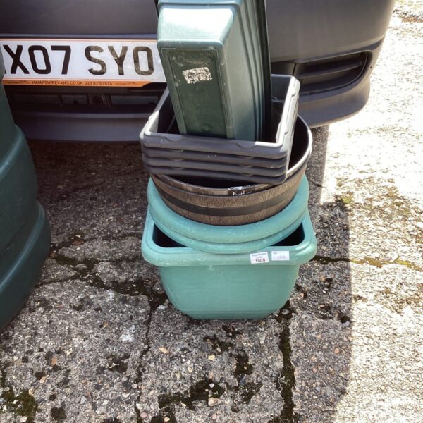 Selection of used plastic garden planters stacked together.