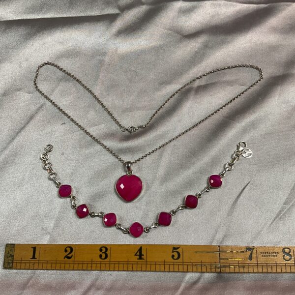Close-up of 925 silver necklace with a pink stone pendant.